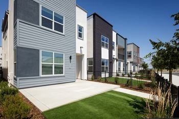 A modern house with a grey facade and a white door.